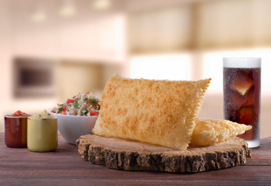 Traditional brazilian pastry (pastel) with vinaigrette and soft drink