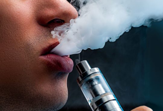 Close up young man vaping e cigarette. new popular vaping devi