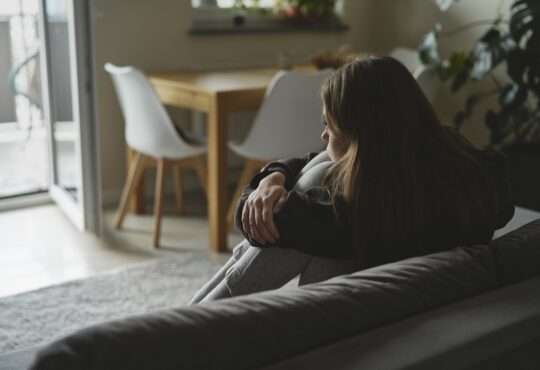 Caucasian sad woman sitting at the sofa with depression