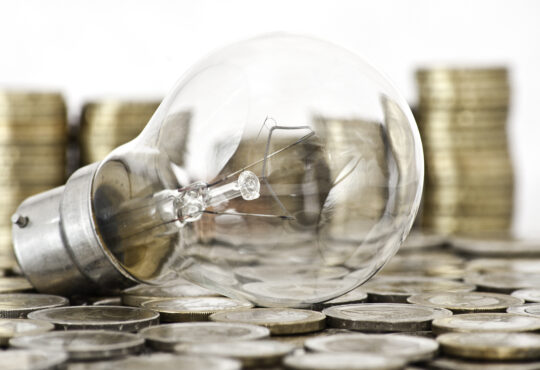 Filament bulb lying on euro coins