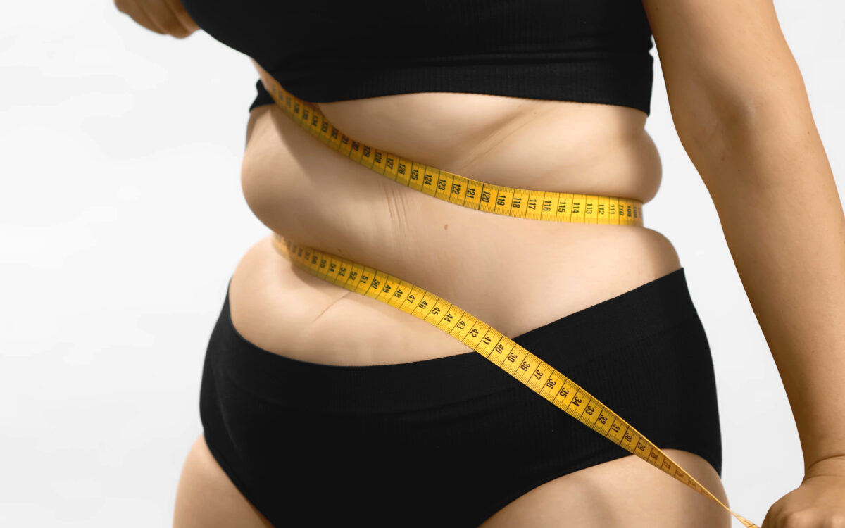 Excess weight caucasian woman wrap measure tape around her waist. shot high quality photo image.