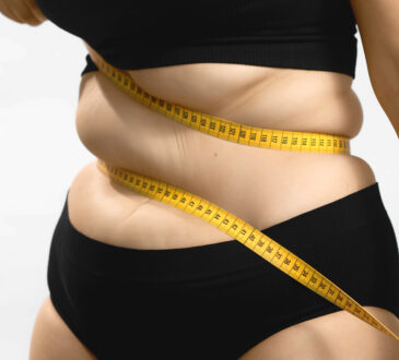 Excess weight caucasian woman wrap measure tape around her waist. shot high quality photo image.