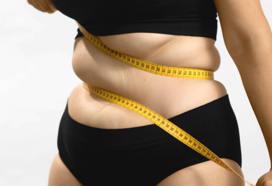 Excess weight caucasian woman wrap measure tape around her waist. shot high quality photo image.