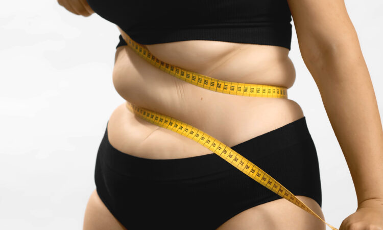 Excess weight caucasian woman wrap measure tape around her waist. shot high quality photo image.