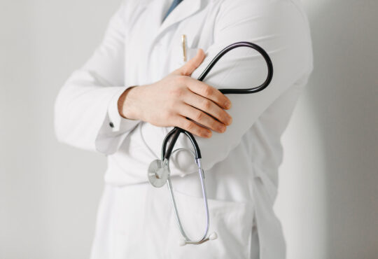 Portrait of a friendly doctor. isolated on gray