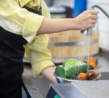 Woman in the kitchen washing vegetables before cooking