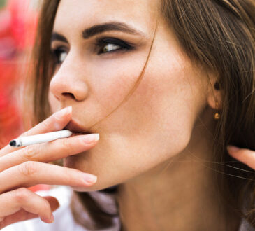 Brunette woman smokes a cigar