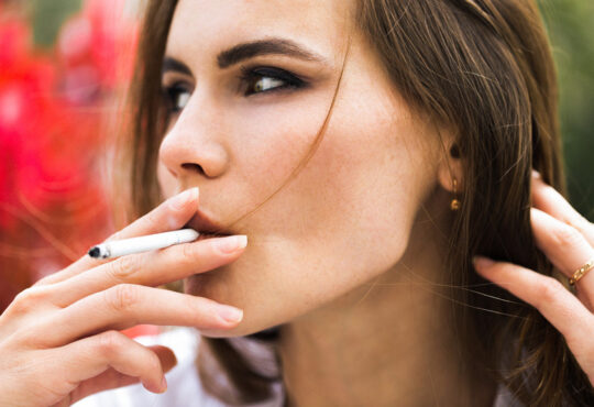 Brunette woman smokes a cigar
