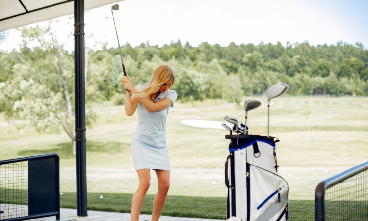 Beautiful girl playing golf on a golf course
